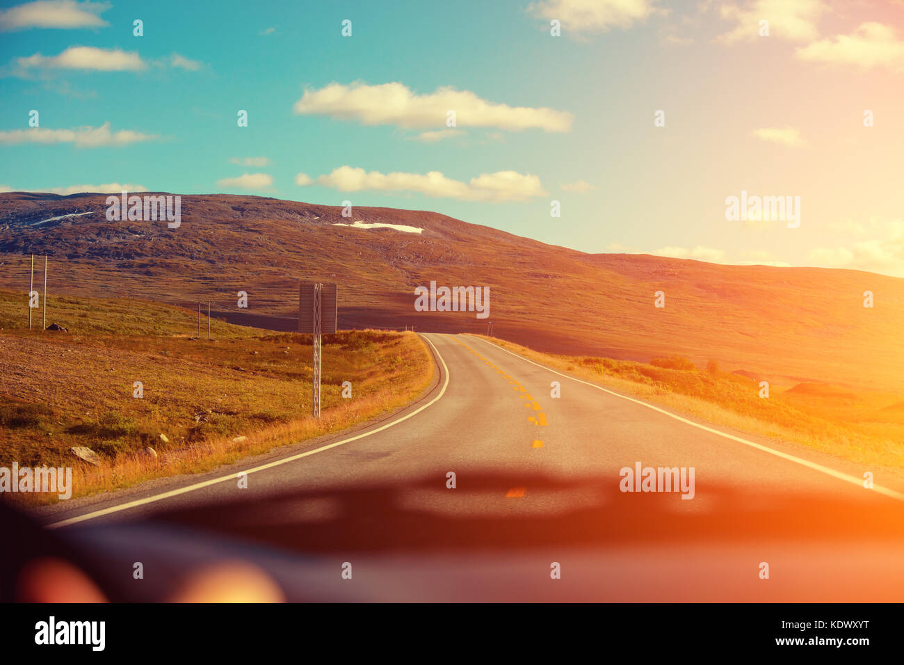 Driving a car on the mountain road at sunset. View from the windscreen ...