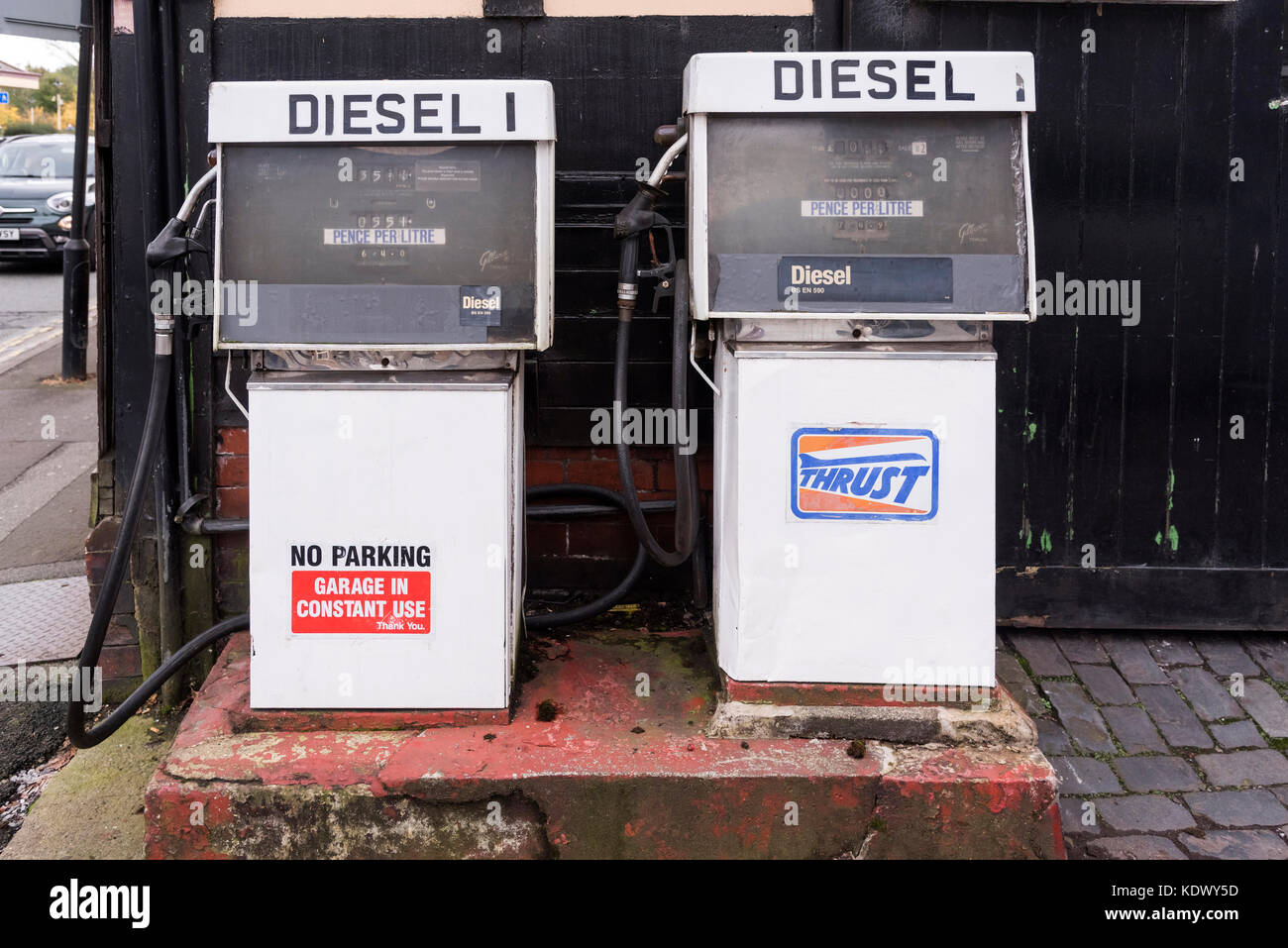 Two old fashion diesel pumps on a garage forecourt. Stock Photo