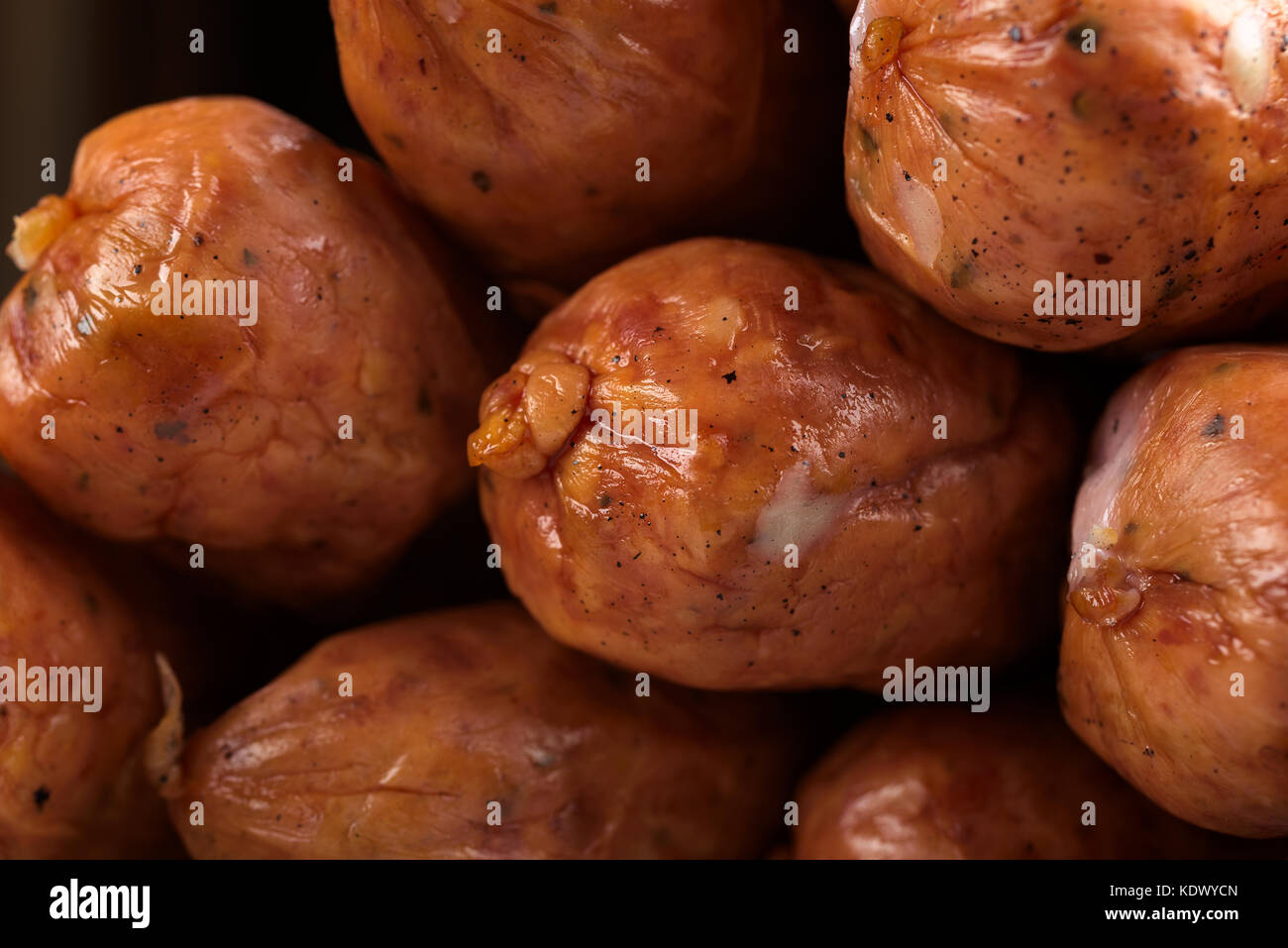 Stack of deliciously cold smoked handmade sausages with visible black