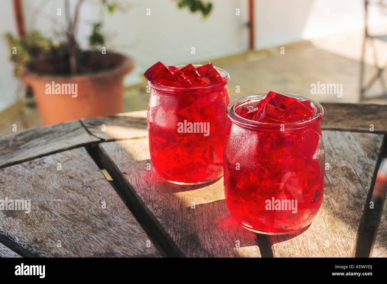red jelly, cut into dice, inside two glasses of glass, on the table