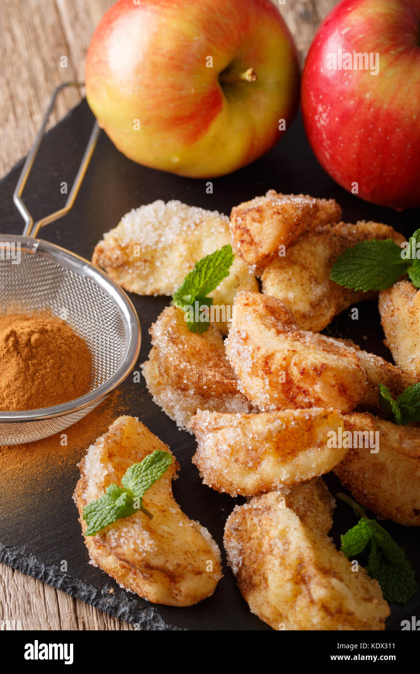 Deep-fried apples with cinnamon and sugar close-up on the table. vertical Stock Photo