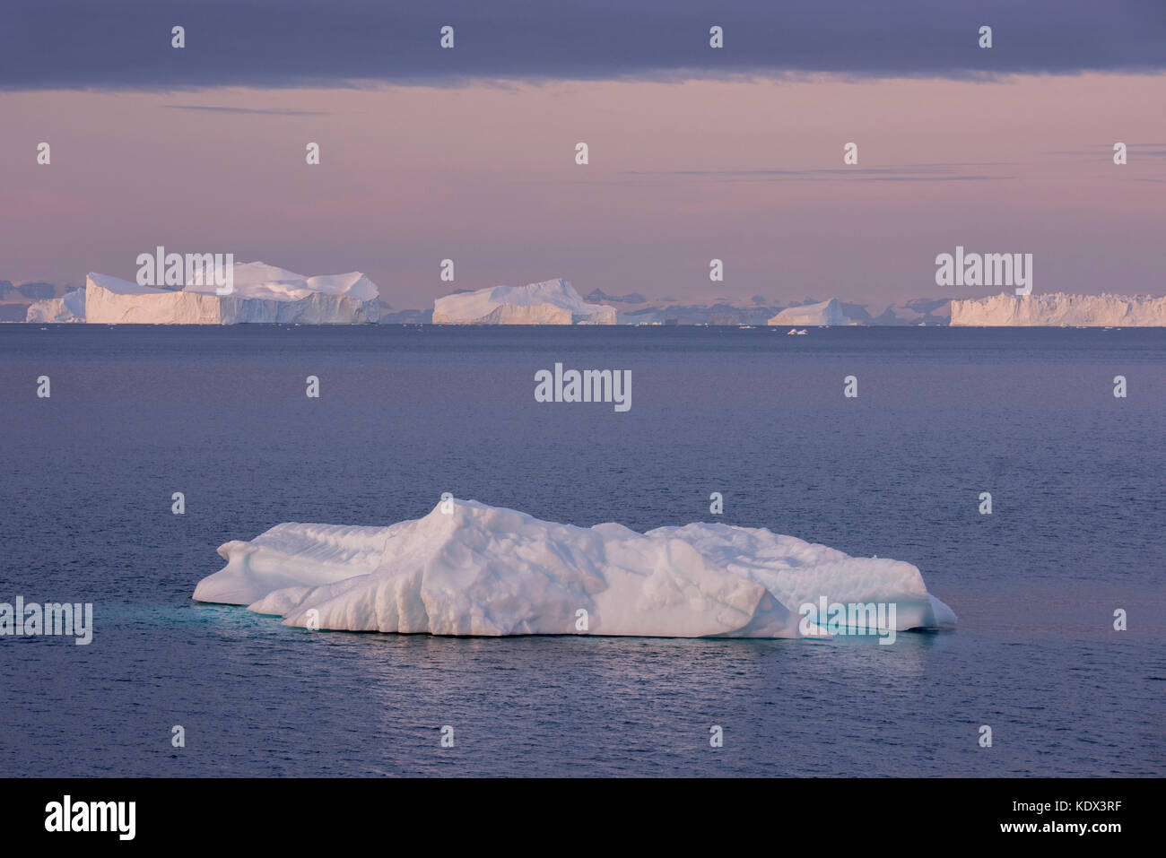 Greenland, Scoresbysund aka Scoresby Sund, Nordvestfjord. Sunrise over huge icebergs. Stock Photo