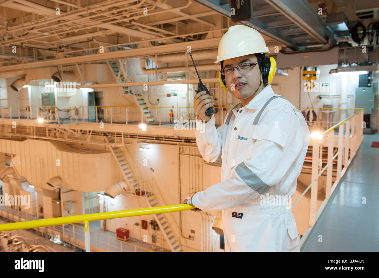 Ship's engineering officer in engine room talking on VHF radio Stock ...