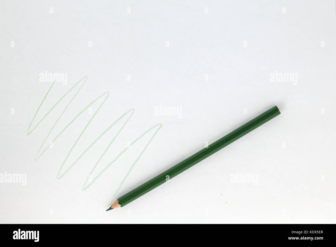 Pencil drawing green zigzag on white paper Stock Photo
