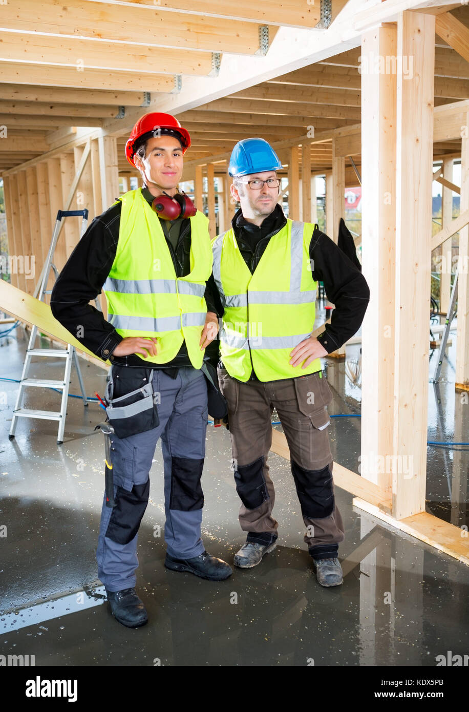 Full length portrait of carpenters in protective clothing at construction site Stock Photo