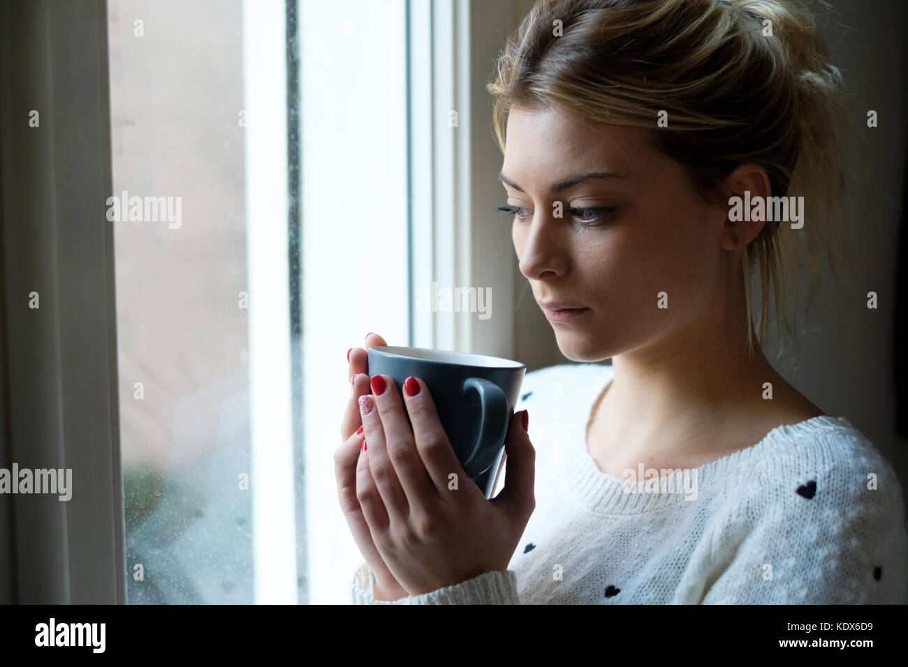 Girl feeling in a bad mood and drinking hot drink Stock Photo Alamy