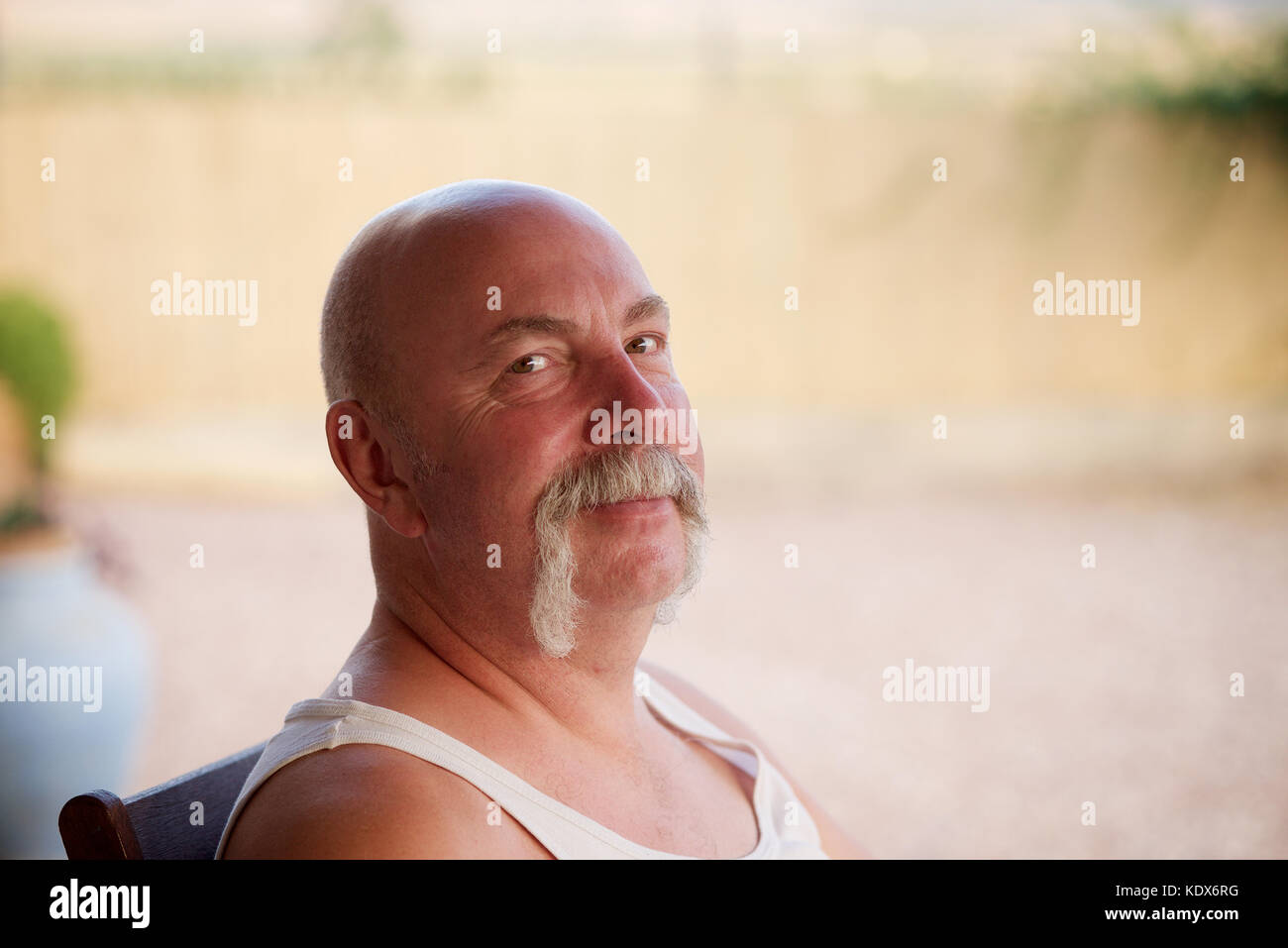 Over 50 man with a moustache sitting outside Stock Photo