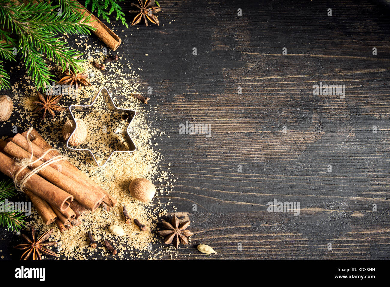 Flour New Year background. Christmas tree branches, gingerbread cookies,  spices and baking supplies on black wood background. Christmas, New Year  gree Stock Photo - Alamy