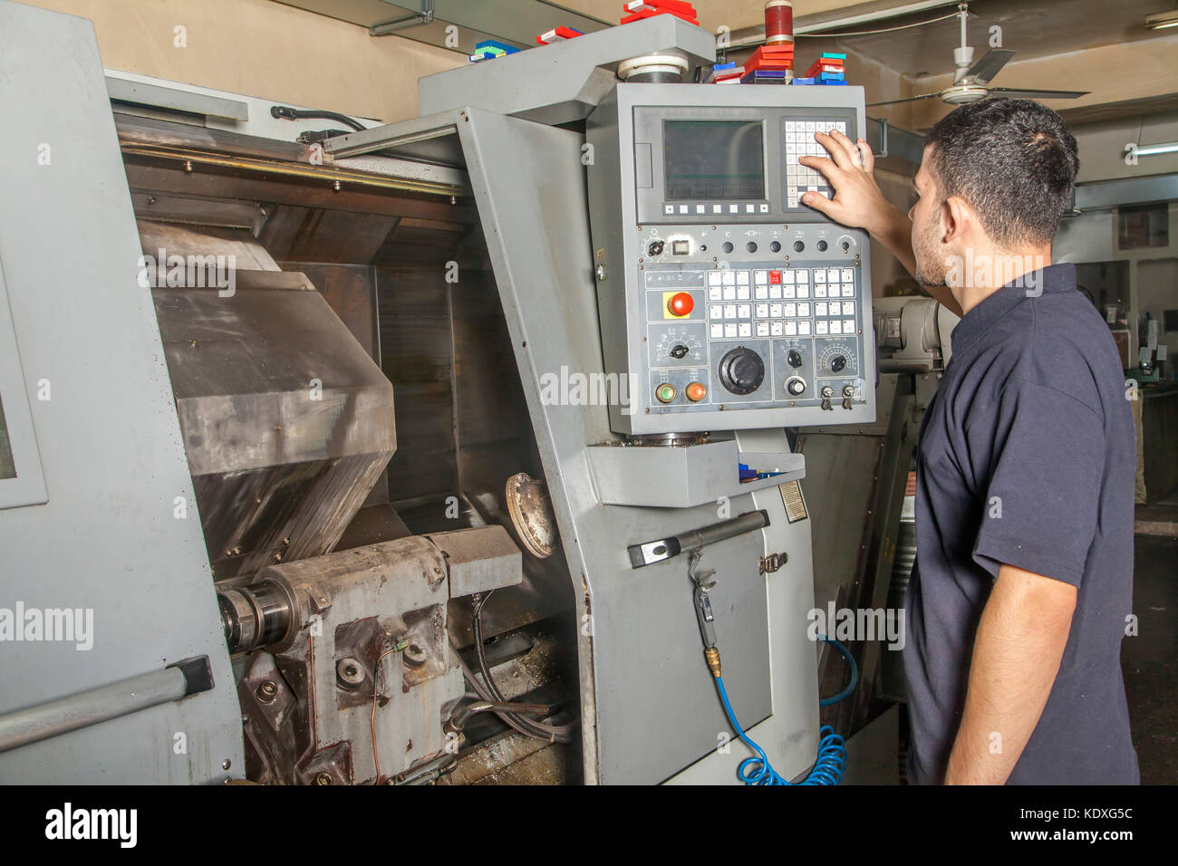 Operator setting up cnc turning machine from control panel Stock Photo ...