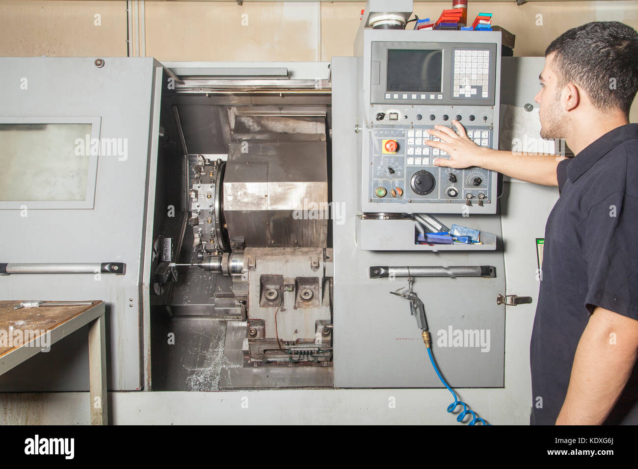Operator setting up cnc turning machine from control panel Stock Photo ...