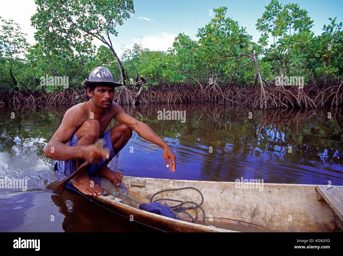 Indonesia. Sulawesi. Sama-Bajau people. Man in canoe paddling by mangroves. Stock Photo