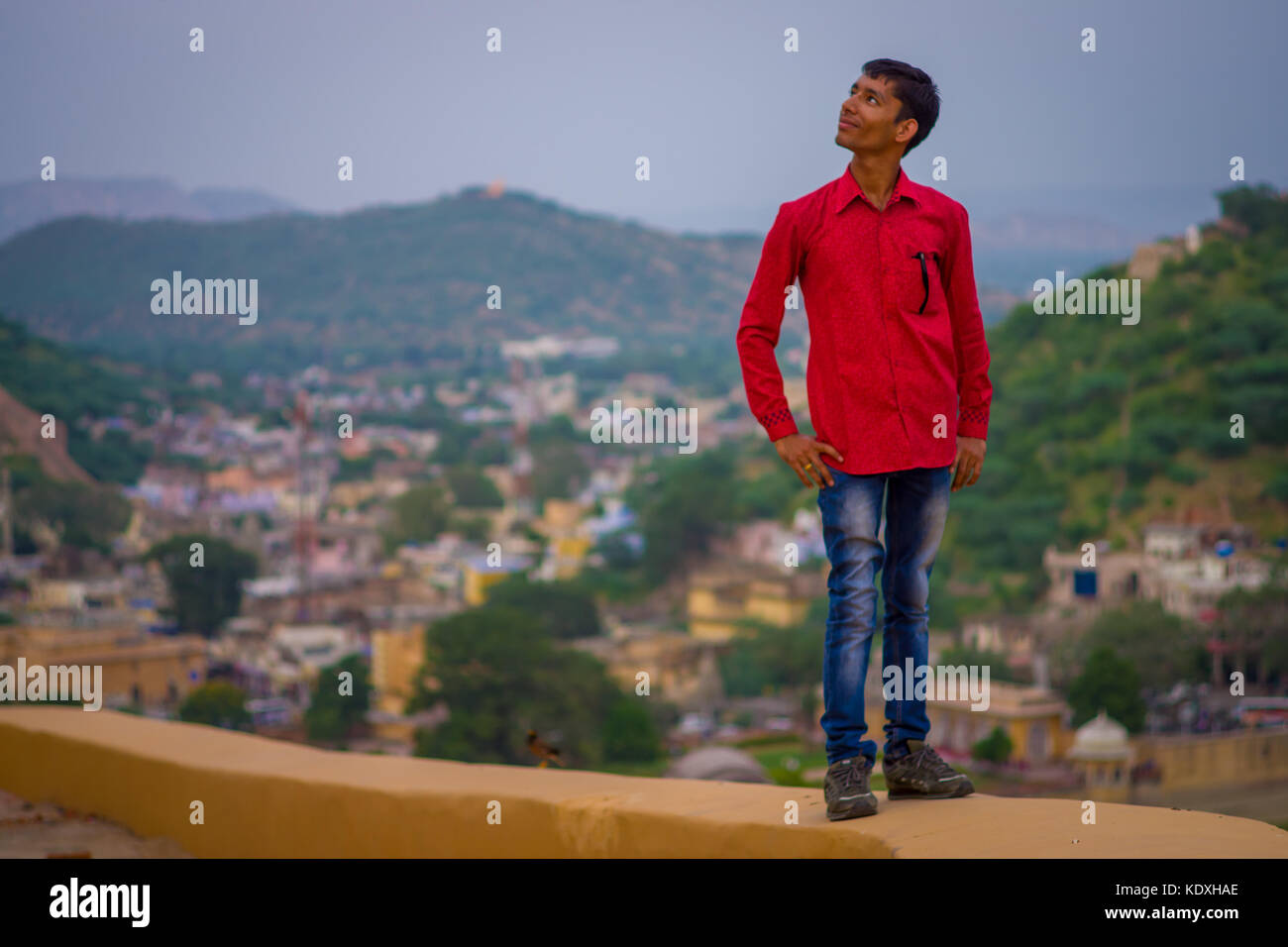 Amber, India - September 19, 2017: Close up of an unidentified Indian man wearing a red t-shirt a jean pants with city behid in the city of Amber, India Stock Photo