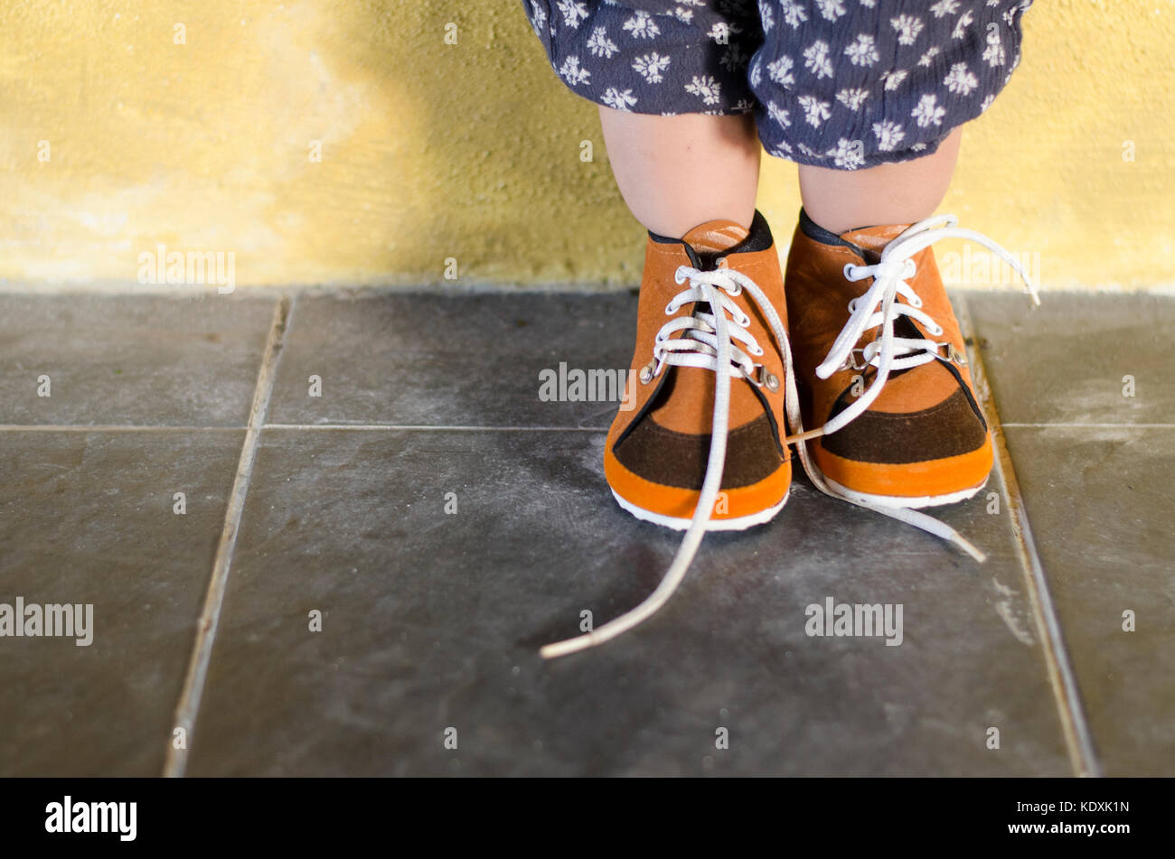 toddler standing while wearing brown shoes. put on your own shoes day