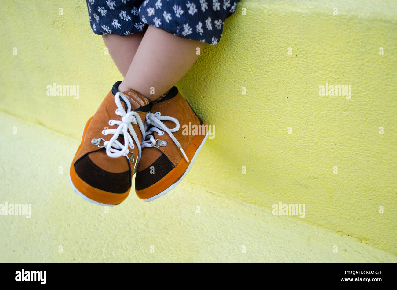 toddler leg wearing brown shoes. put on your own shoes day. wear brown