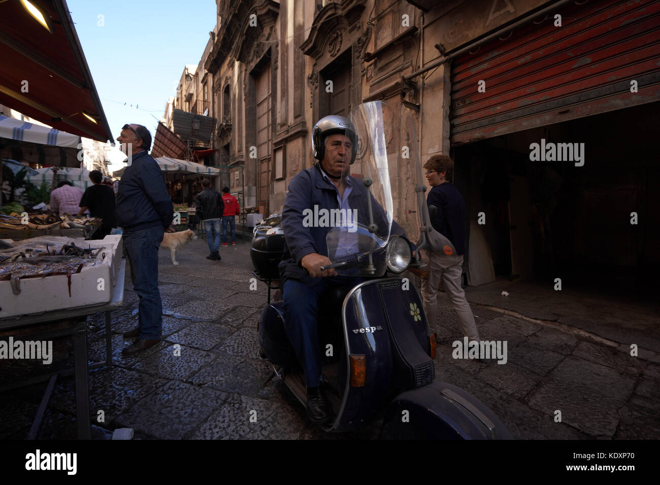A man riding a moped in the back streets of Palermo. From a series of ...