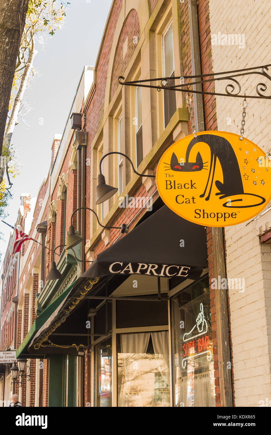 Black awning and yellow sign advertise businesses in HIstoric Downtown Wilmington, NC Stock Photo