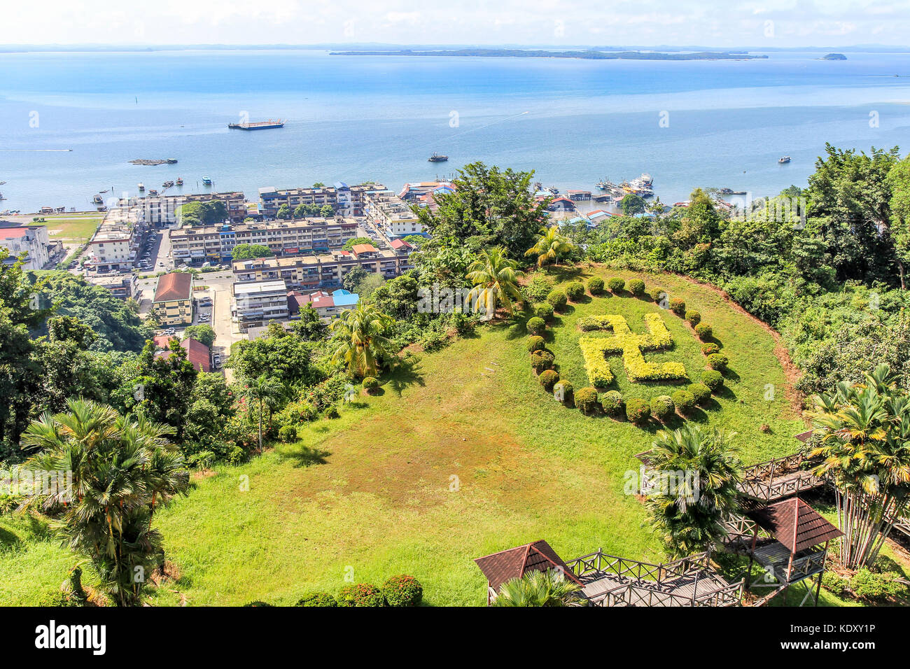 Sandakan town landscape with green lawn in Hindu counterclockwise swastika shape and blue Sulu sea in the background, Borneo, Malaysia Stock Photo