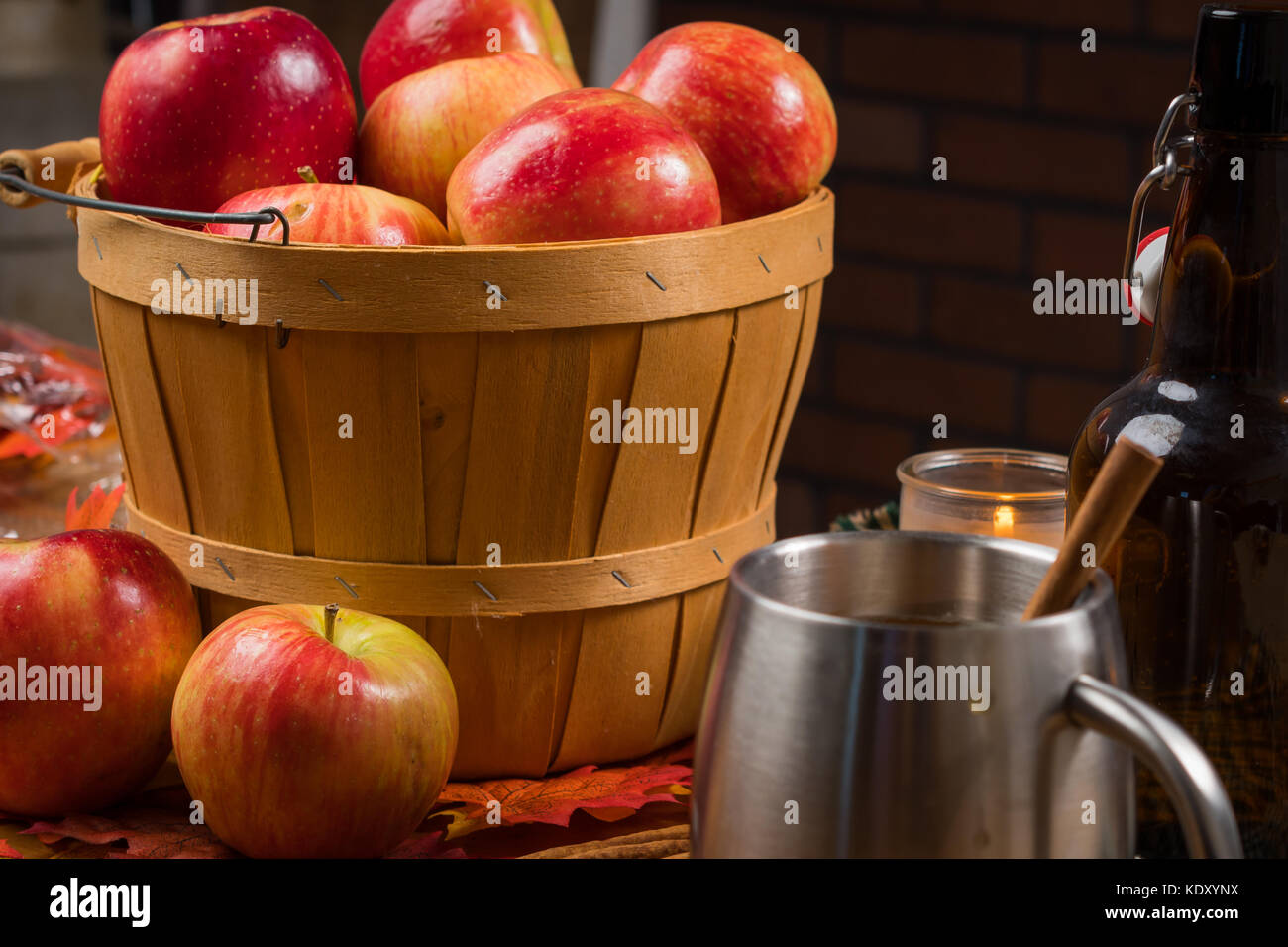 Wooden basket of apples with a cup and bottle Stock Photo