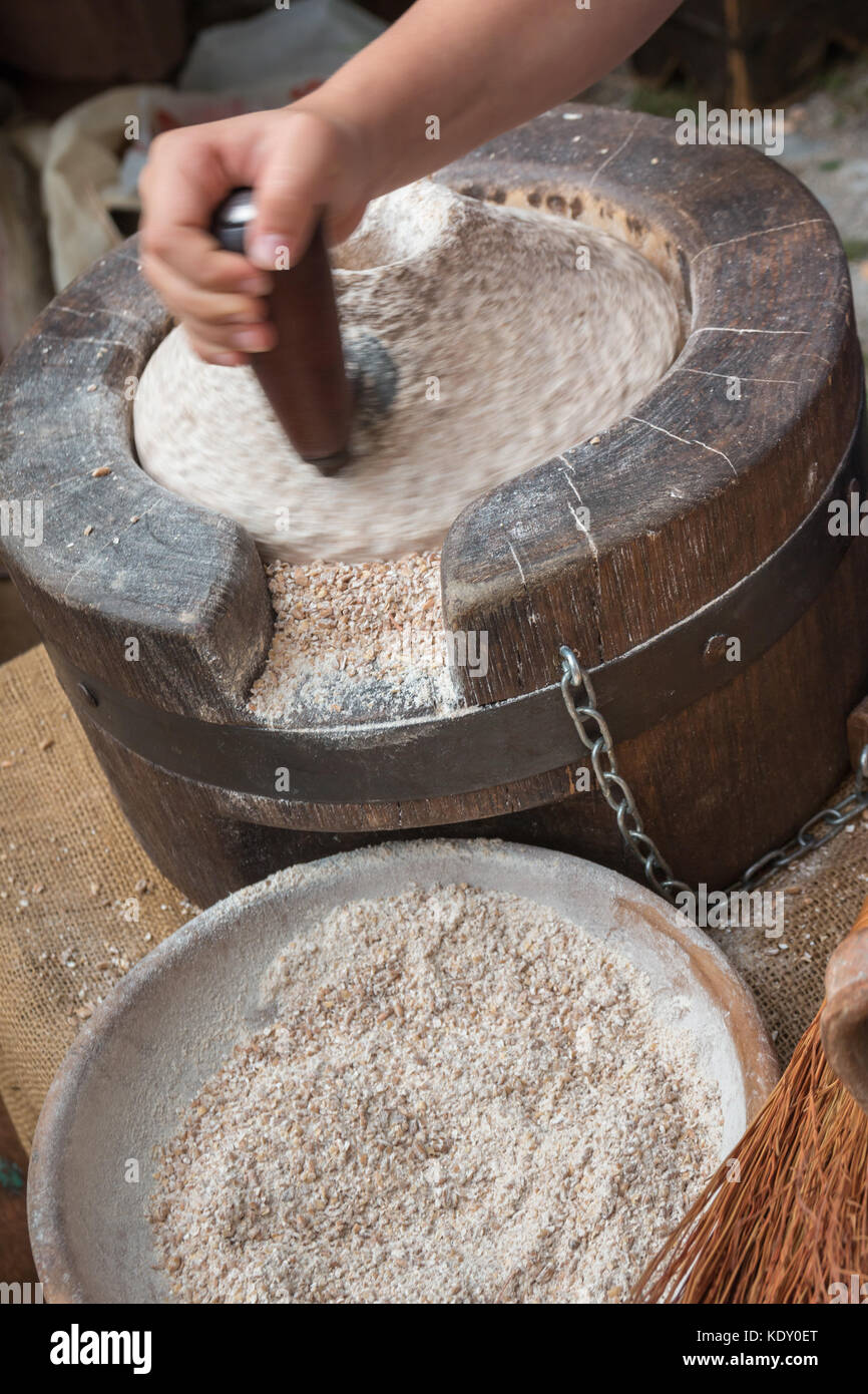 Using an Ancient Manual Stone Mill Stock Photo Alamy