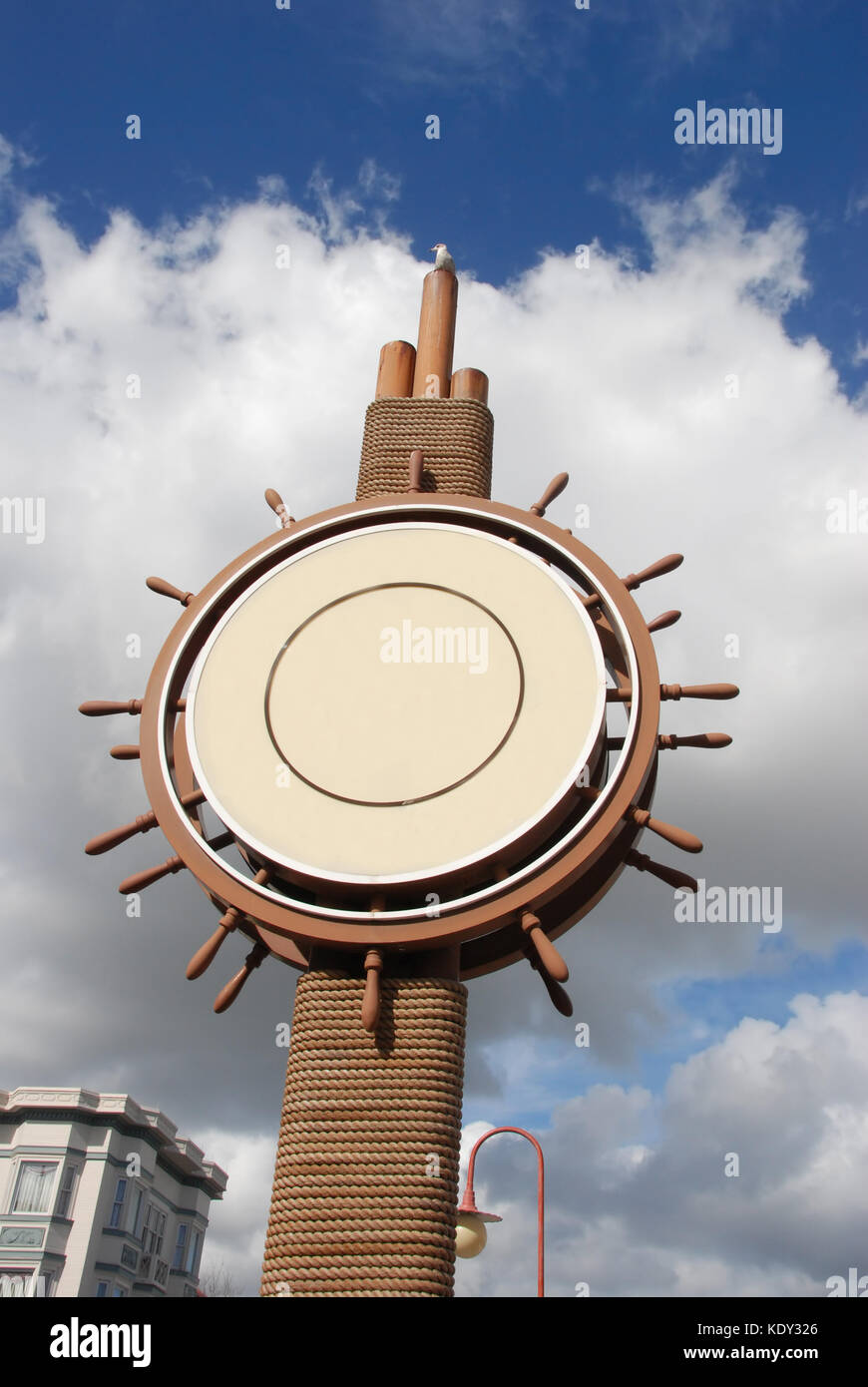 Outdoor sign in the shape of ship wheel Stock Photo - Alamy