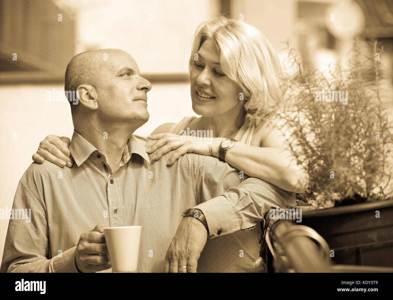 Positive elderly couple having morning coffee at balcony Stock Photo