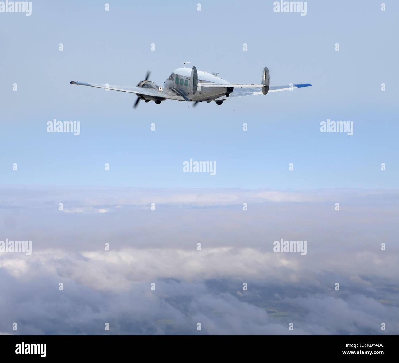 Retro propeller airplane flying high above the clouds Stock Photo - Alamy