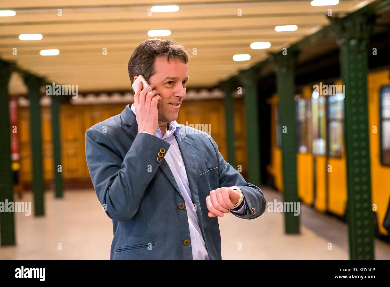 A middle age businessman standing and waiting in the subway while ...
