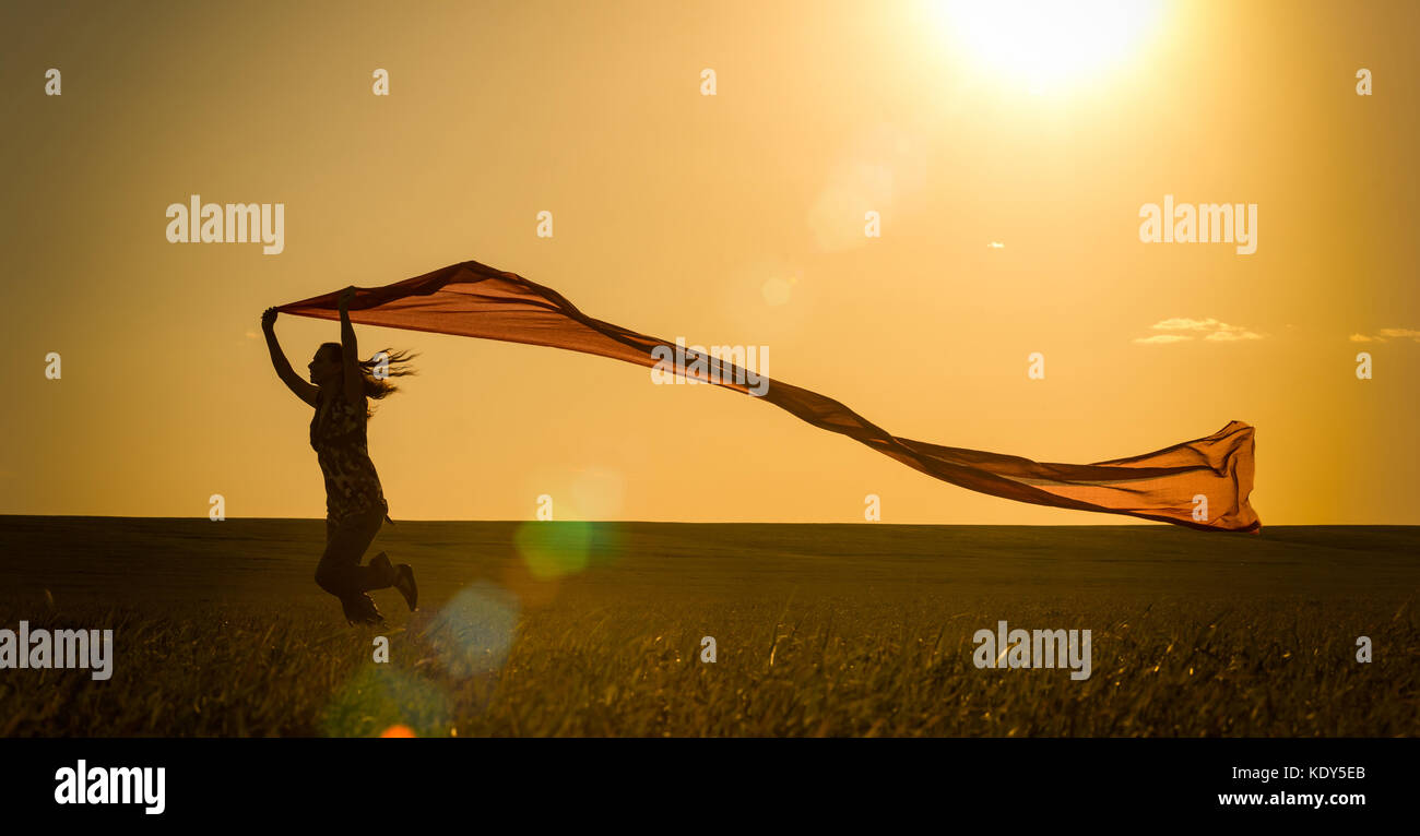 Young woman running on a rural road at sunset in summer field. Lifestyle sports freedom background Stock Photo