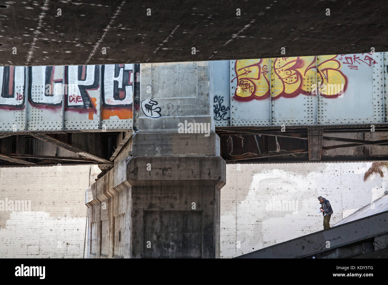 Homeless man under a bridge at the Confluence, Los Angeles, River, Los Angles, California, USa Stock Photo