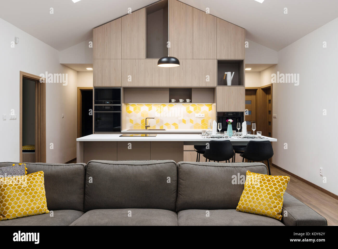Living-room connected with kitchen in background, contemporary house  interior Stock Photo - Alamy
