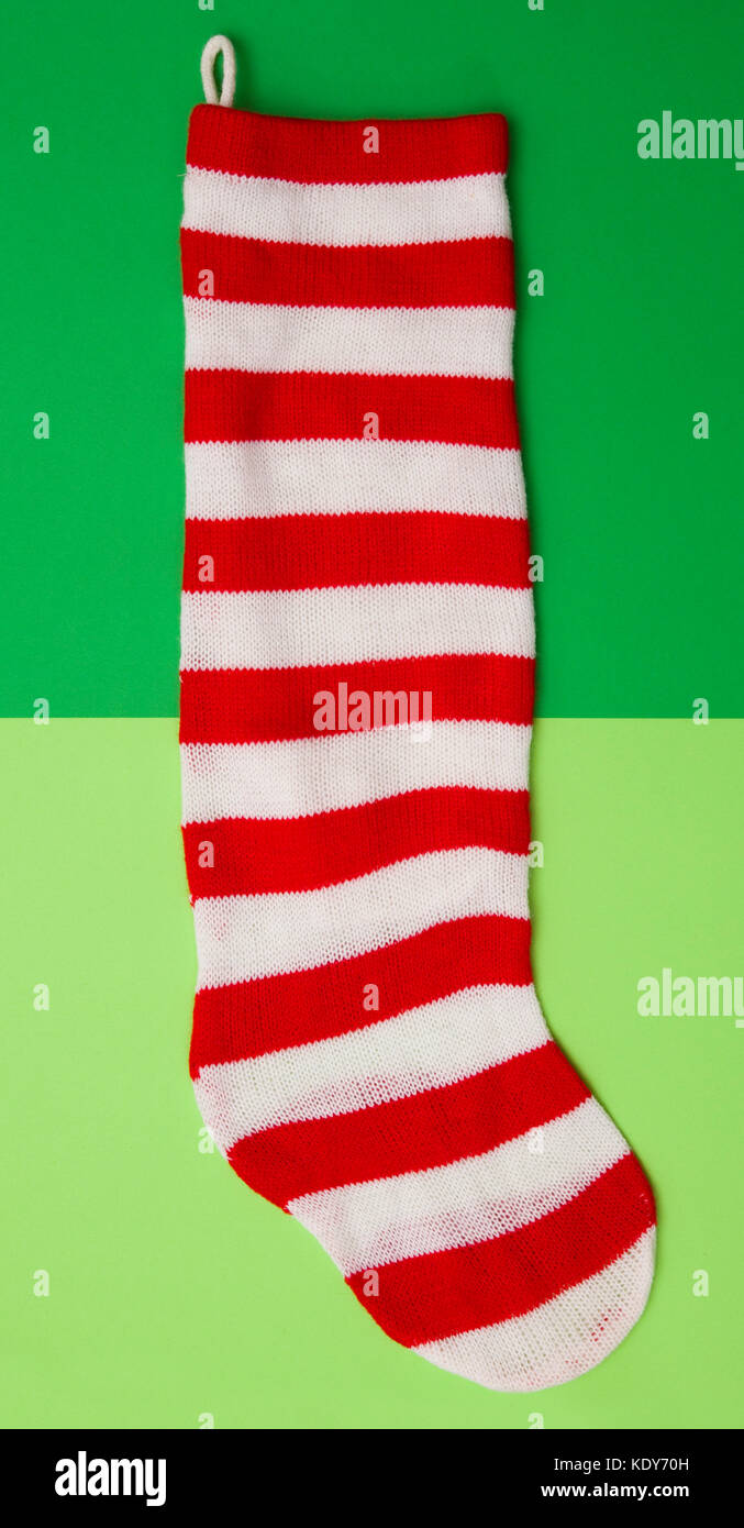 Red and White Striped Stocking on a Duel Green Background Stock Photo