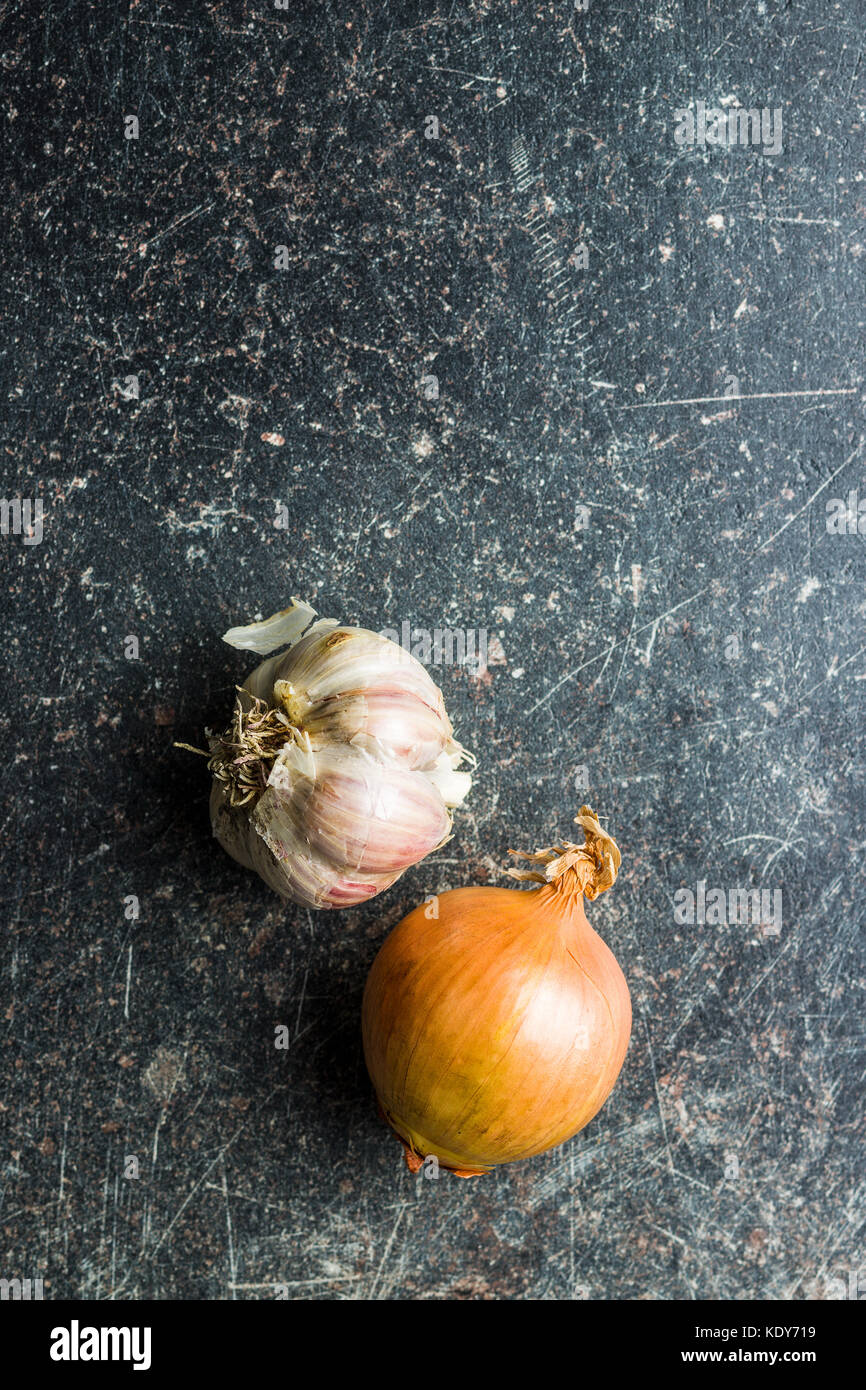 Fresh onion and garlic bulbs on old kitchen table Stock Photo Alamy