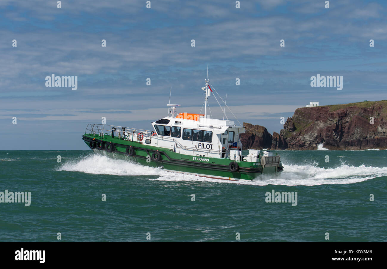 The pilot vessel St Govan taking a pilot out to a ship through the swell at the entrance to Milford Haven waterway on a fine summers morning. Stock Photo