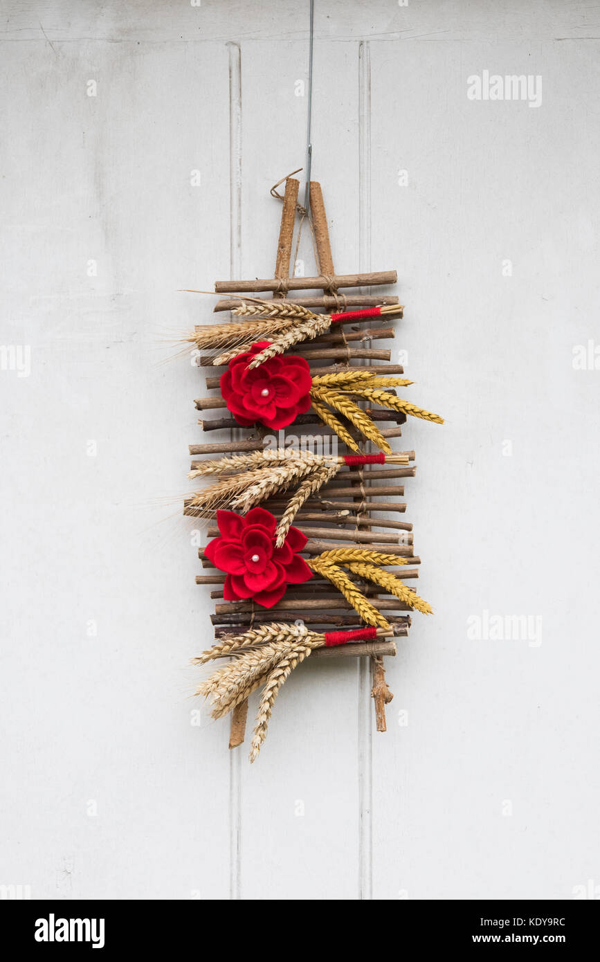 Autumn flower wood and wheat decoration on a medieval house door at Weald and Downland open air museum, autumn show, Singleton, Sussex, England Stock Photo