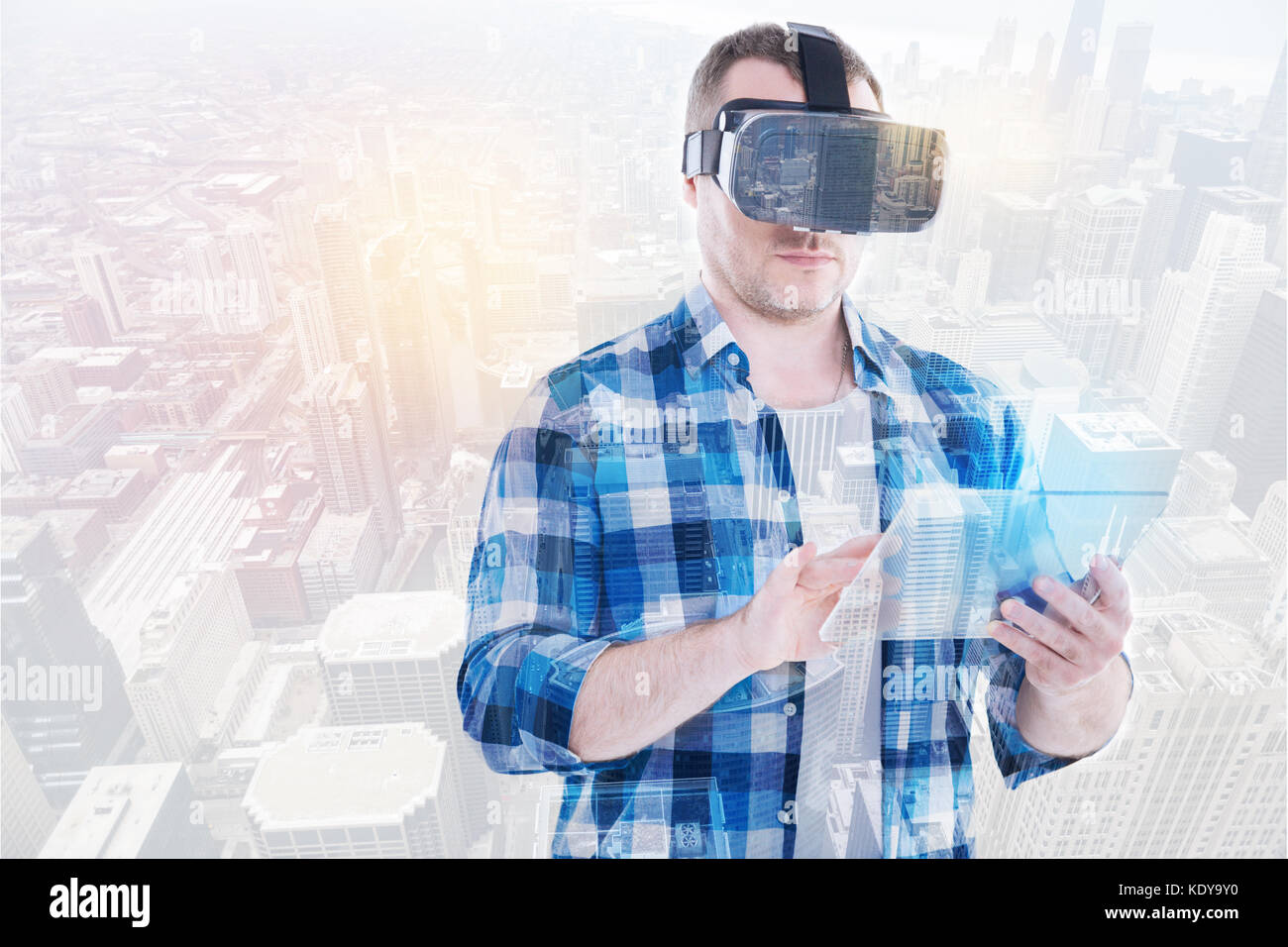 Young man using tablet while wearing VR headset Stock Photo - Alamy