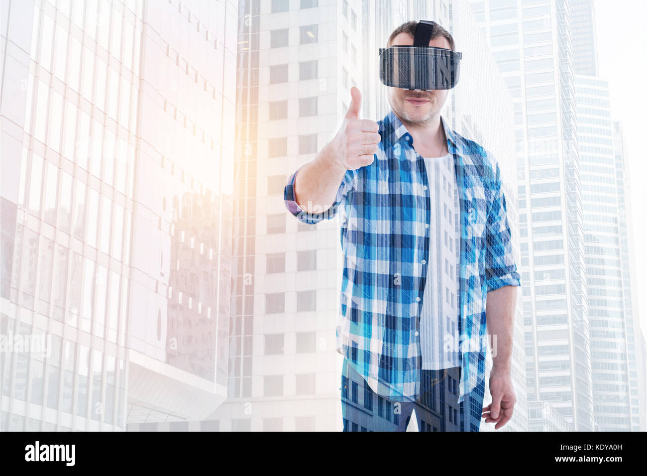 Pleasant man in VR headset showing thumbs up Stock Photo - Alamy