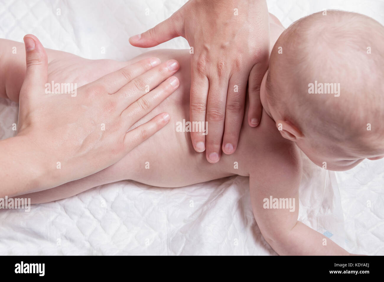 Three month baby boy receiving back massage from a female massage therapist Stock Photo