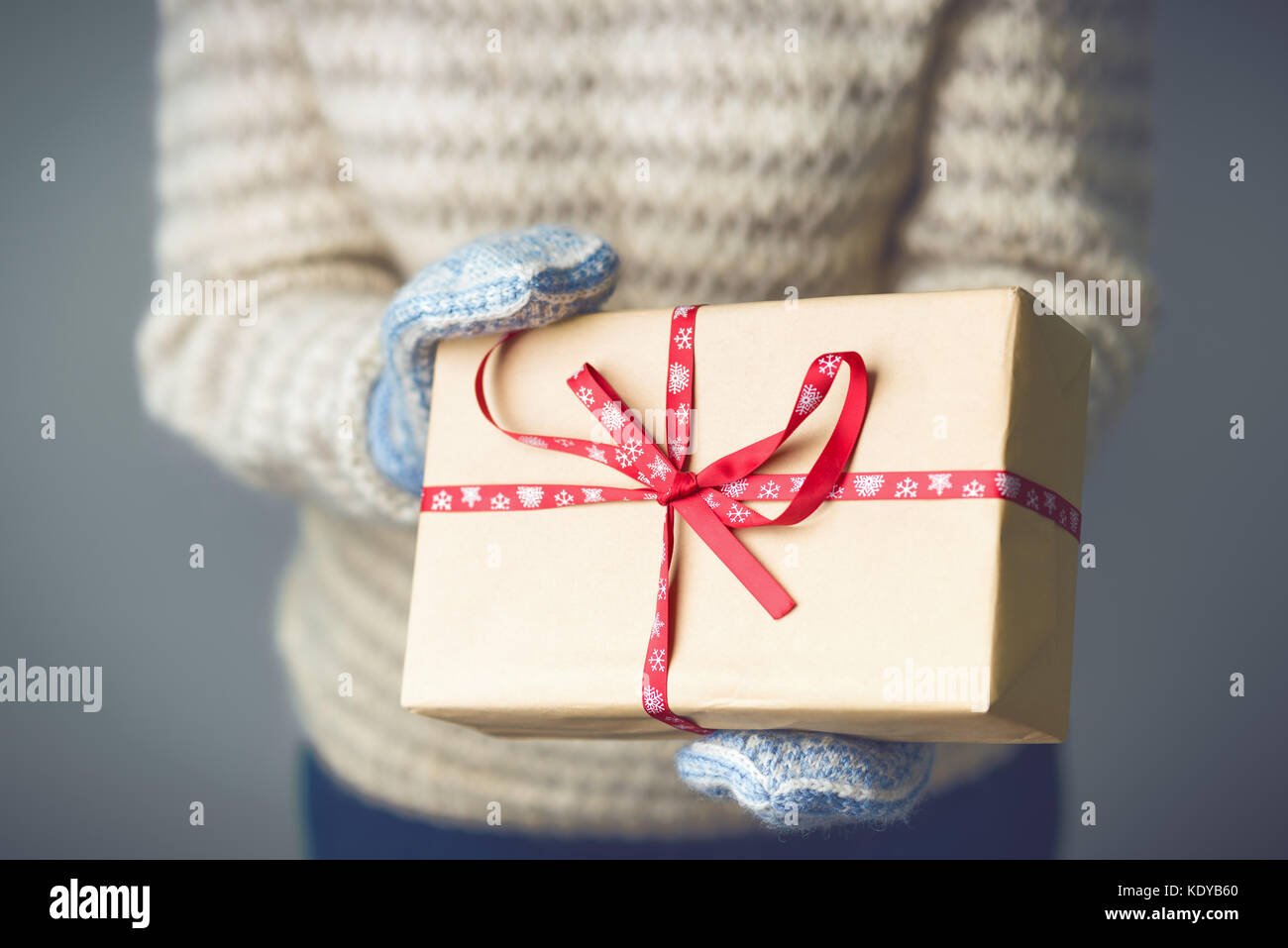 A girl holding a box with a Christmas present Stock Photo - Alamy