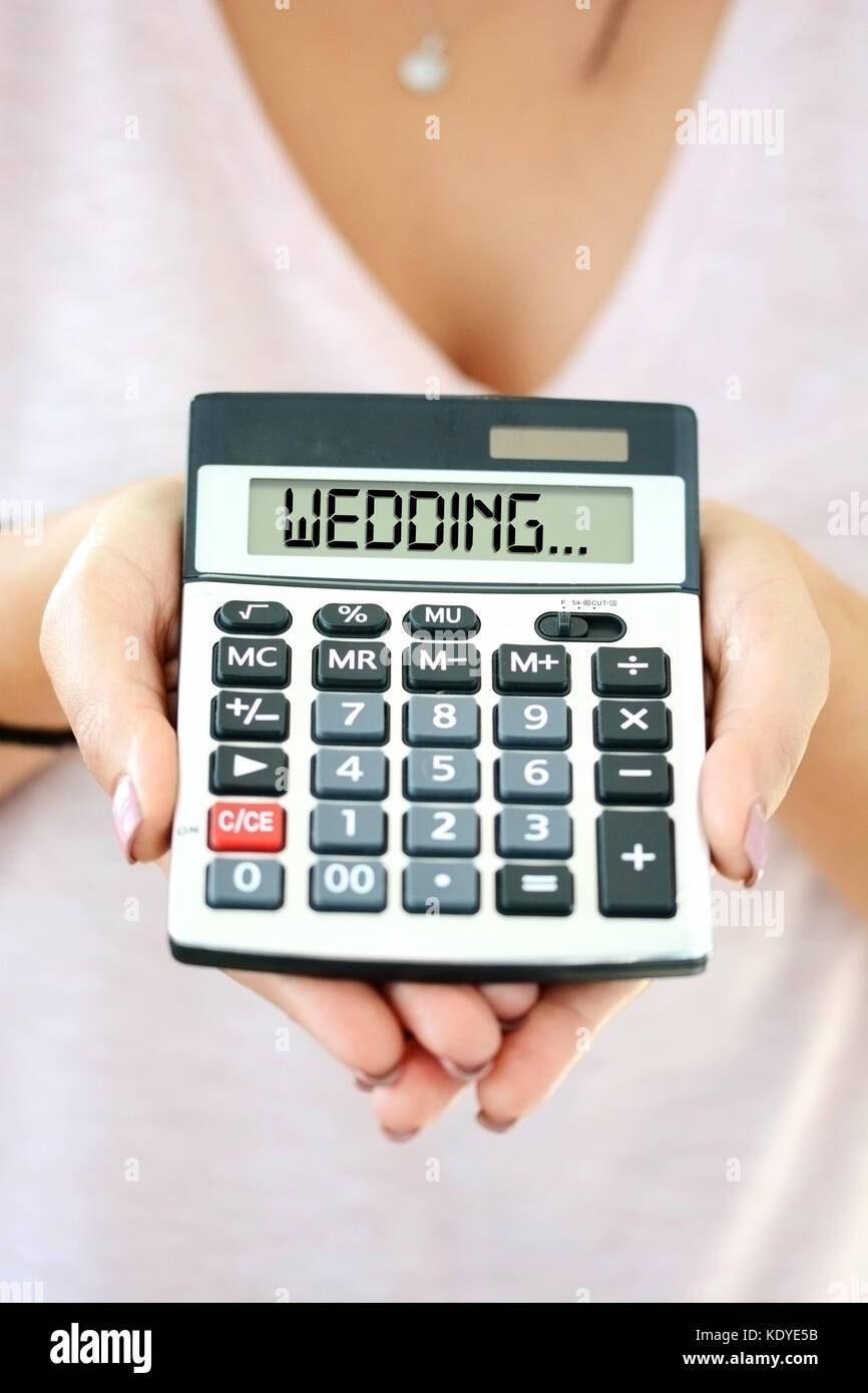 Conceptual image, cost of a wedding with calculating machine on woman hand Stock Photo