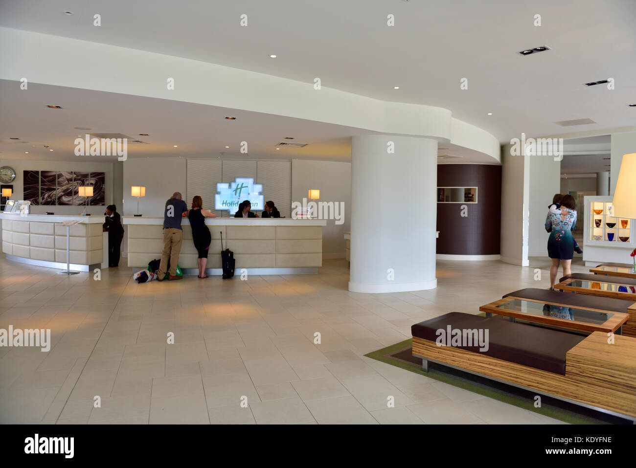Inside hotel lobby with guests at reception desk of Holiday Inn, Reading, Berkshire, UK Stock Photo