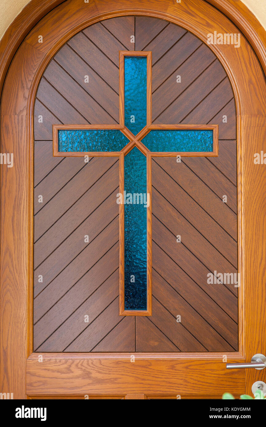 blue glass cross on wooden door, close up Stock Photo