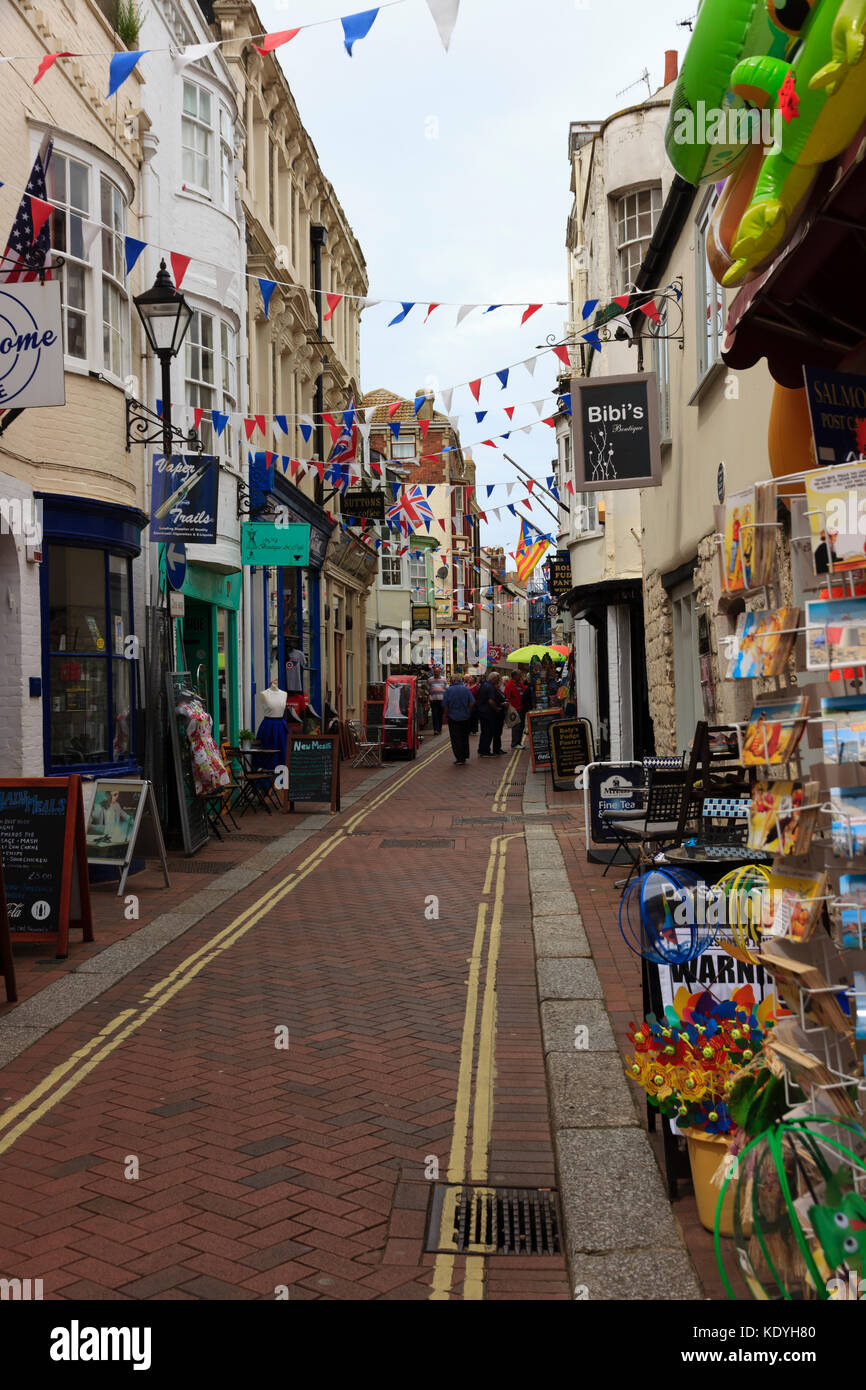 Colourful bunting and shop displays attract visitors to St Alban Street, Weymouth, Dorset, UK Stock Photo