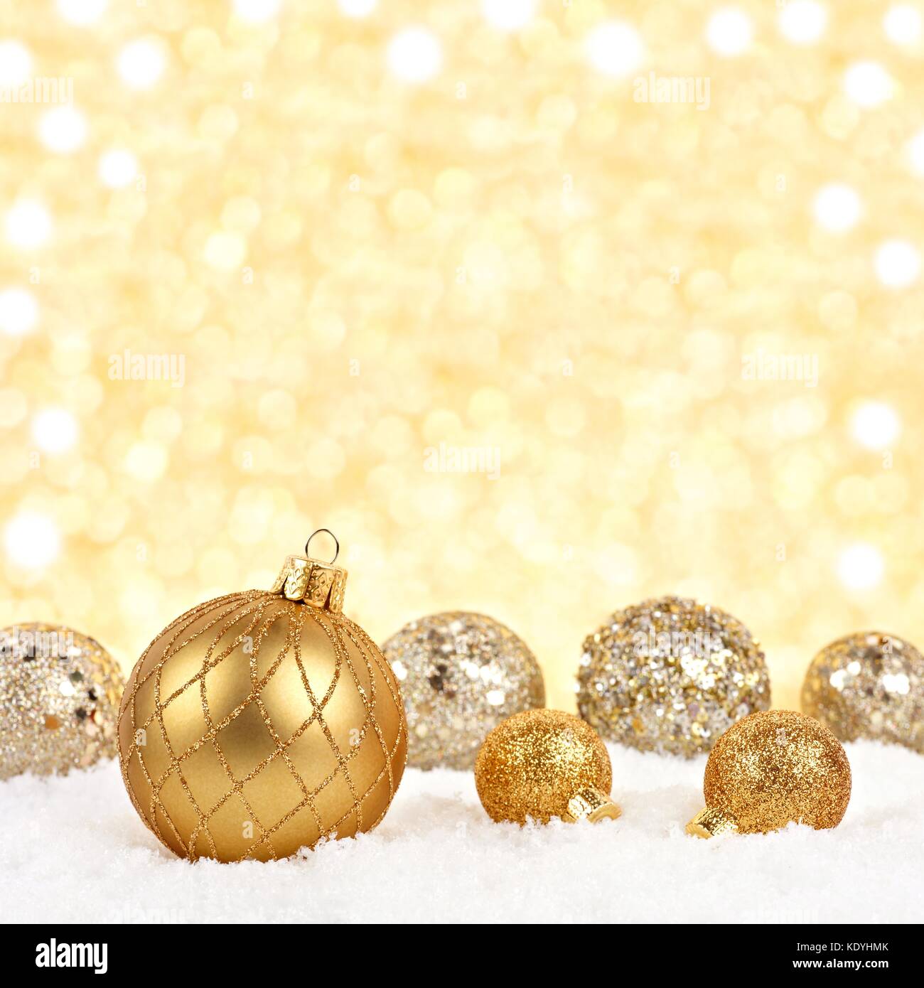 Golden Christmas ornaments in snow with twinkling gold background Stock  Photo - Alamy