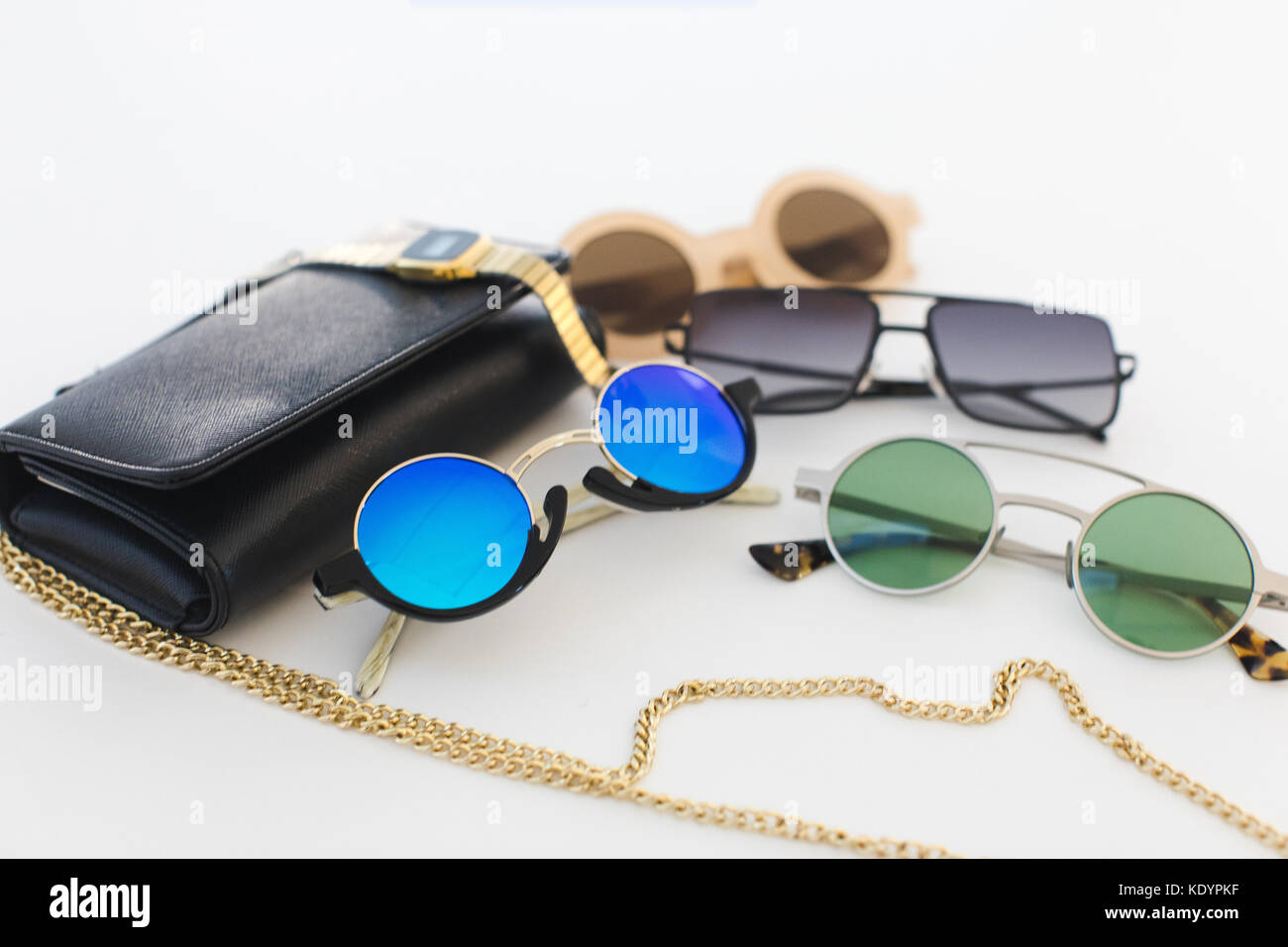Different sunglasses and handbag on a white background Stock Photo