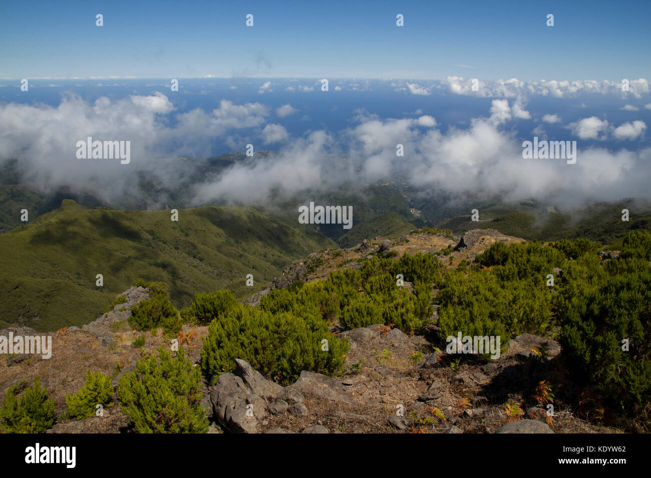 Dramatic view of green mountains with view of ocean and cloudy sky ...