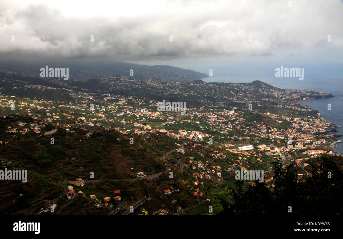 Dramatic view of green mountains with houses and ocean view with cloudy ...