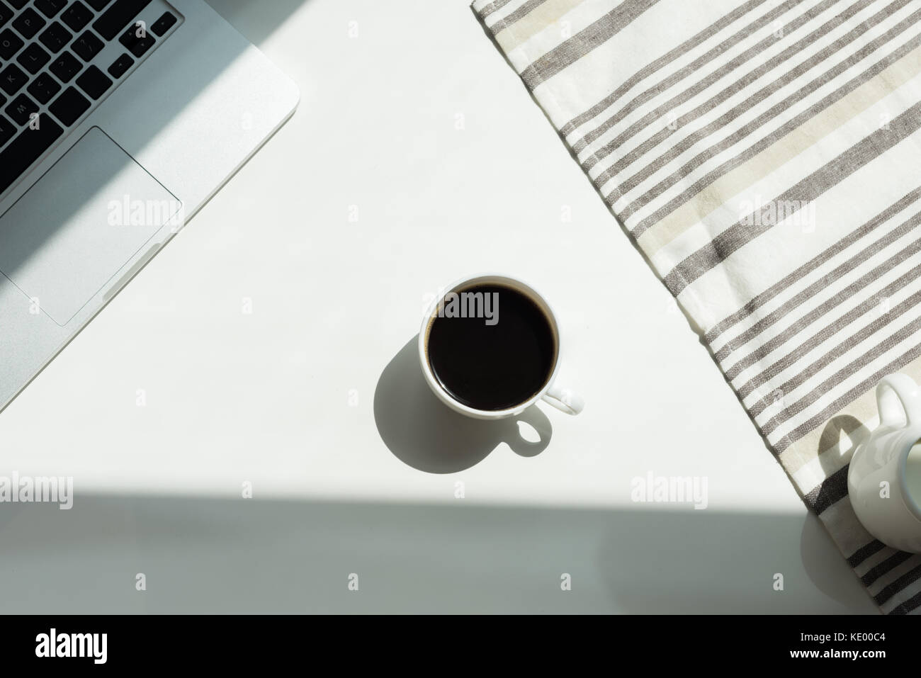 White working desk with laptop computer and cup of black coffee and ...