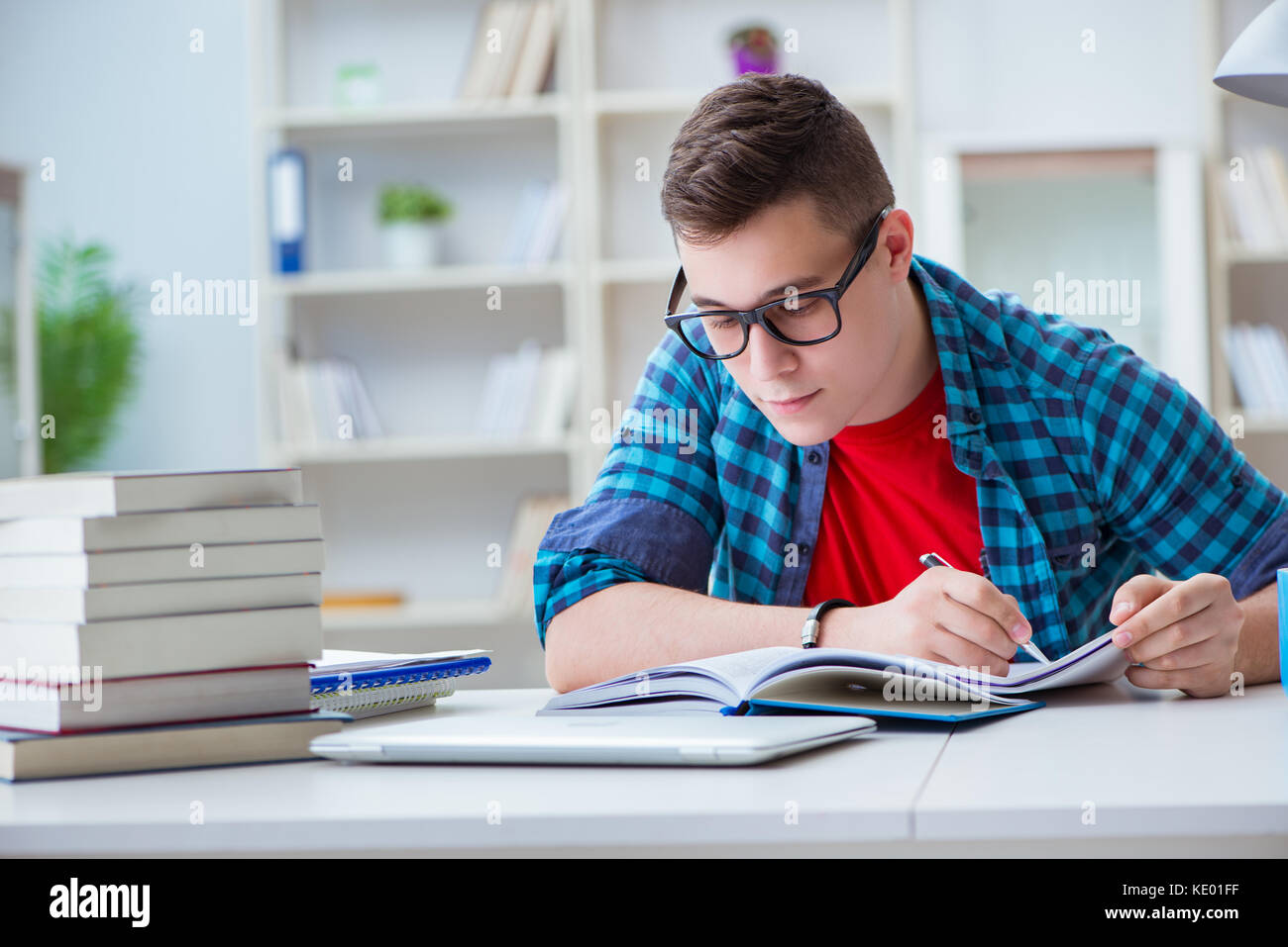 Student Preparing Young teenager preparing for exams studying at a desk indoors Stock ...