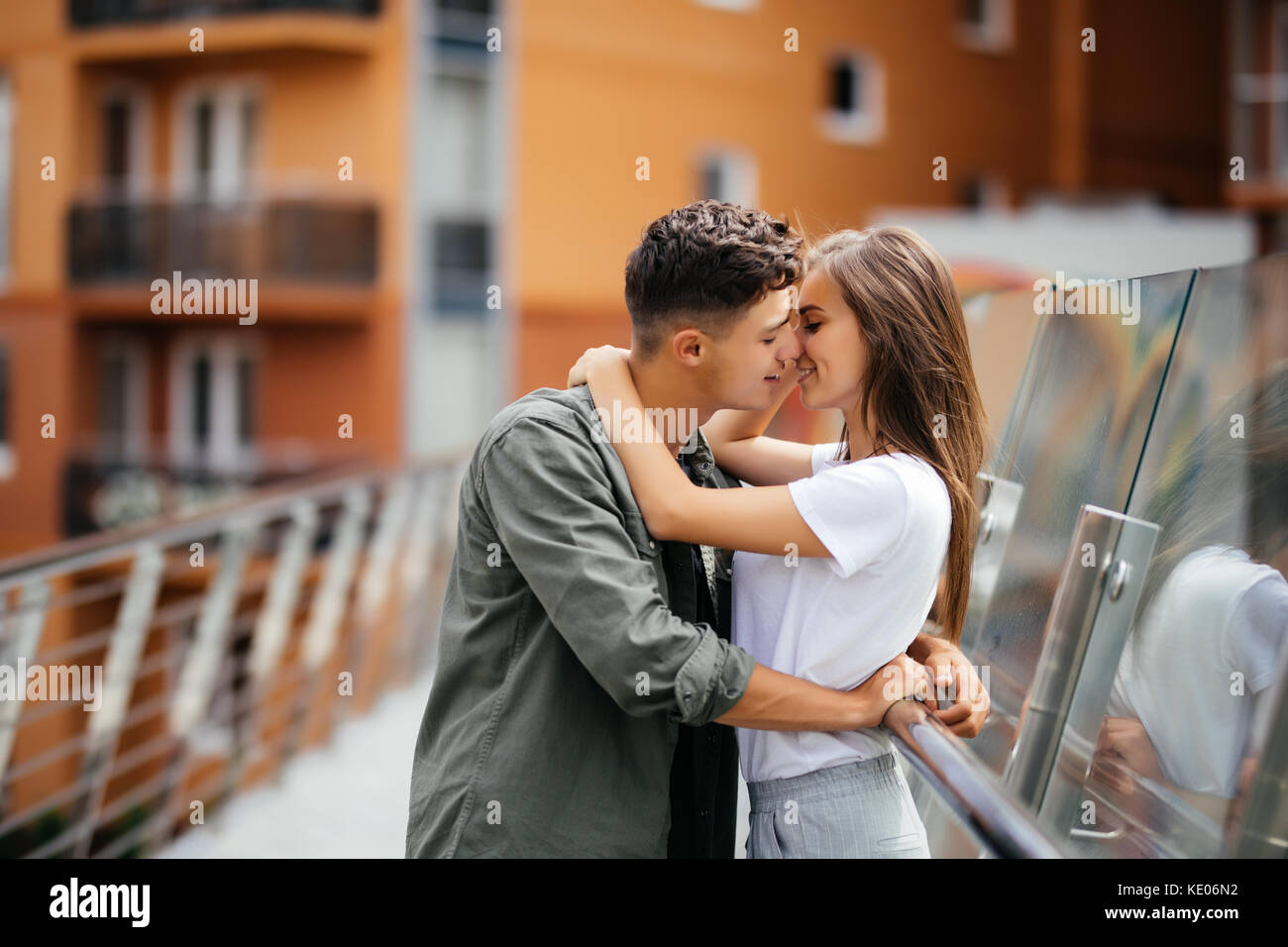 Couple kissing dating on bridge during sunset Stock Photo - Alamy