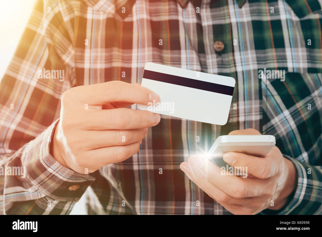 young man holding credit card and use smartphone pay shopping online concept Stock Photo